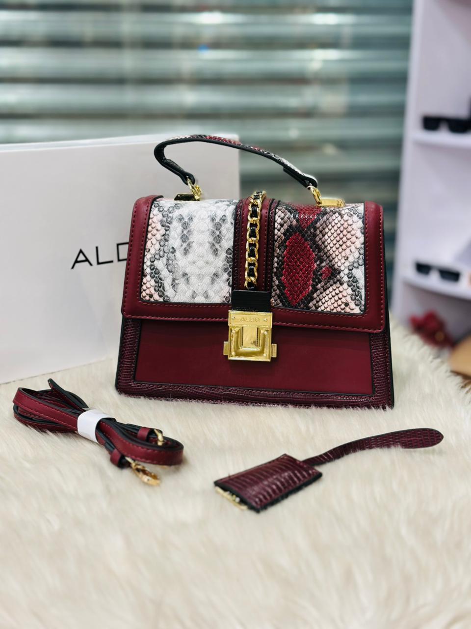 Designer handbag with snake skin pattern on a white surface