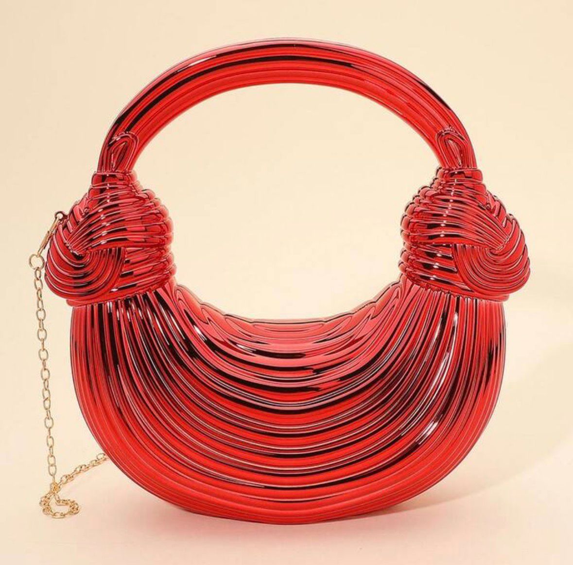 Red woven handbag with a gold chain on a beige background
