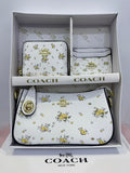 Coach handbag set with floral pattern in a box on a light gray background