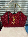 Red quilted handbag with gold chain strap on a white surface