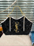 Black handbag with gold chain and logo on a white surface